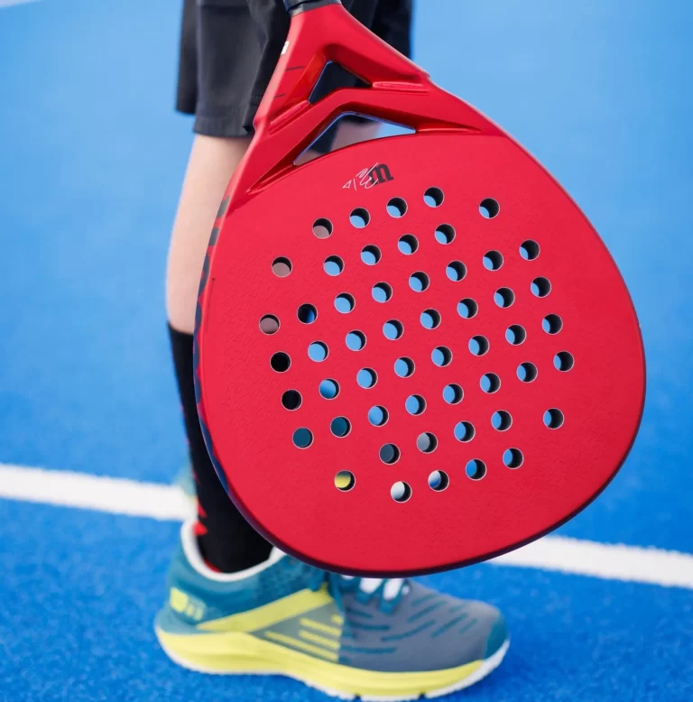 Ett barn som håller i sitt padelracket Wilson Bela Junior V2.